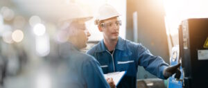 Two workers at a work site with one providing consulting.