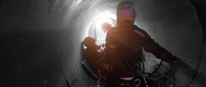 Rescue workers inside of a confined space wearing safety equipment