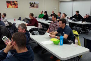 Indoor classroom image of people being trained at desks