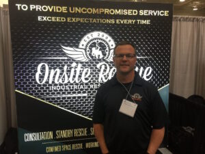 Man standing in front of a Onsite Rescue sign.